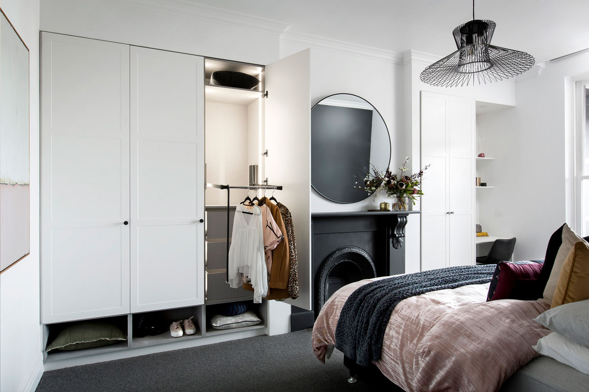 Hinged built in white wardrobe with white shaker-style doors and storage accessories.