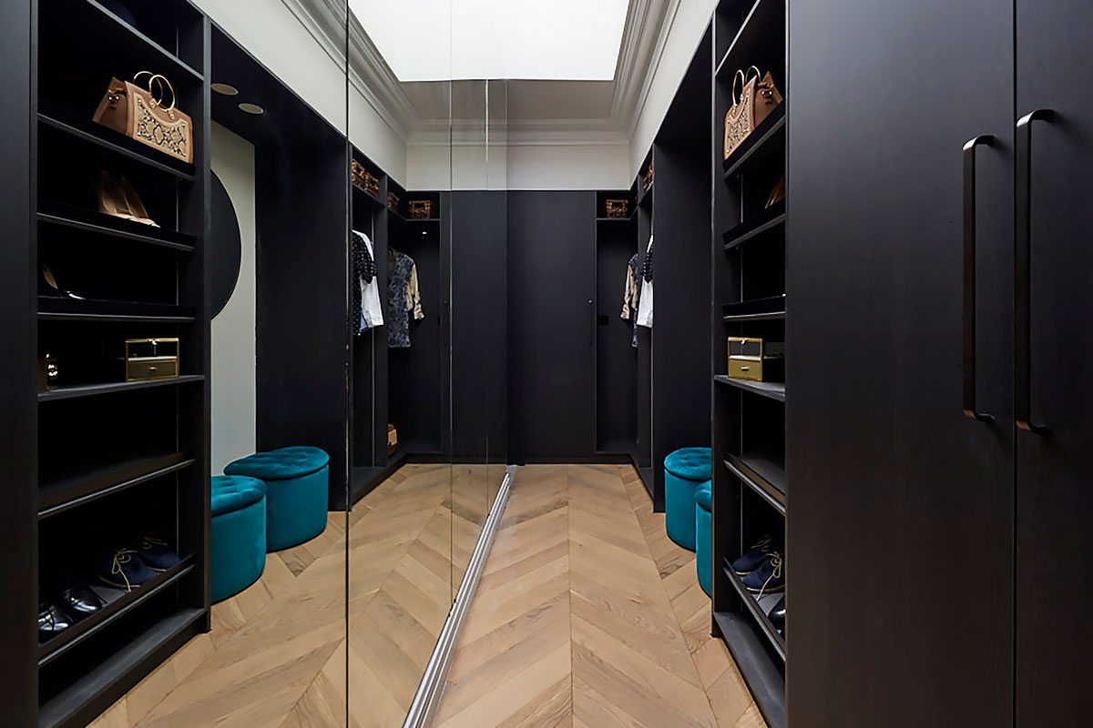 Modern walk in wardrobe with black cabinetry and mirrors