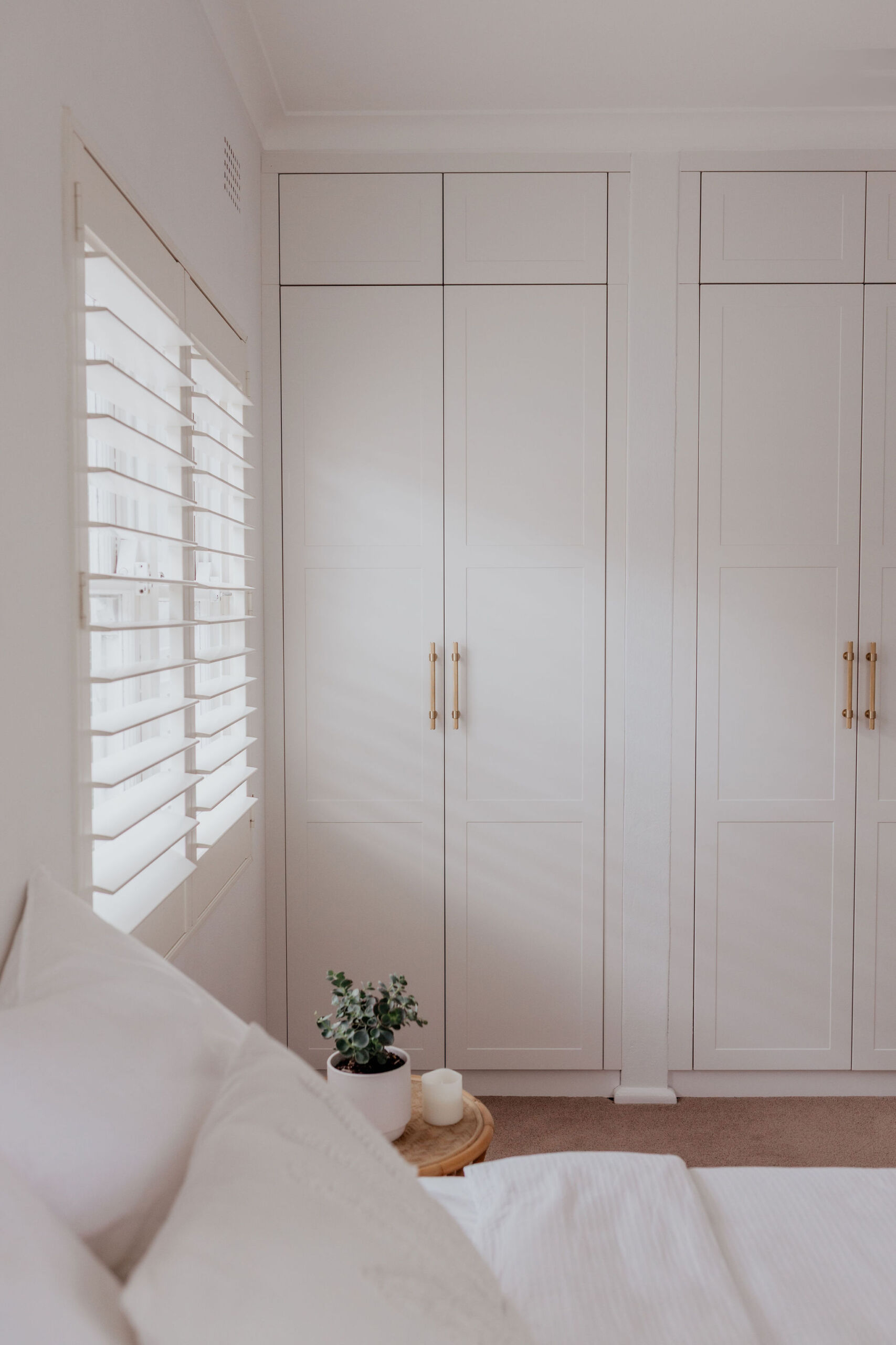 097A2153 White Shaker-style built in wardrobe with gold handles.